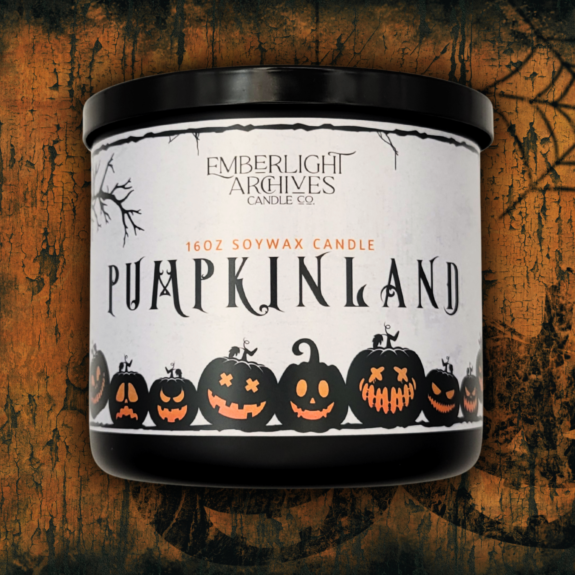 16oz Pumpkinland seasonal pumpkin pie soy candle in a premium black glass jar against a textured orange background with Halloween designs.