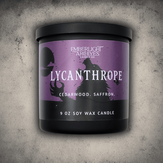Emberlight Archives Lycanthrope horror candle – 9oz black glass jar with purple werewolf label against a gray stone background, Cedarwood & Saffron scent.