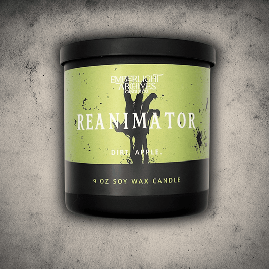 Emberlight Archives Reanimator candle in a 9oz black glass jar with bright green skeleton label against a gray stone background, Dirt and Apple scent.