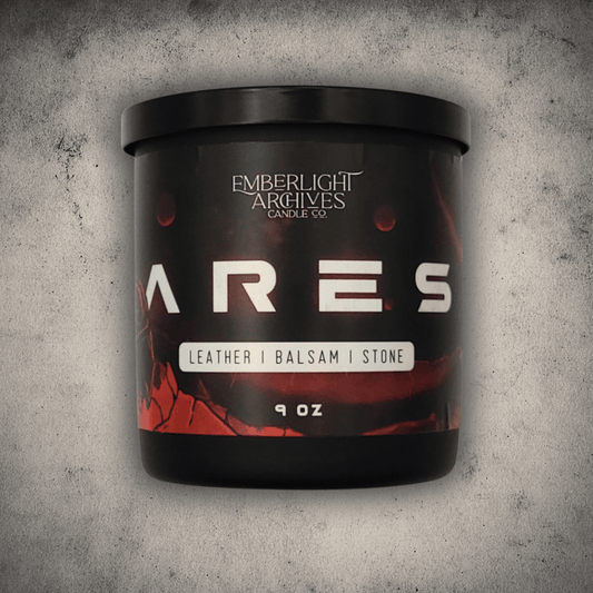 Emberlight Archives Ares candle in a 9oz black glass jar with illustrated red planet label against a gray stone background, Leather and Balsam scent.