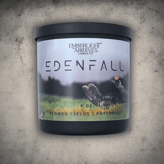 Emberlight Archives Edenfall candle in a 9oz black glass jar with illustrated sci-fi label against a gray stone background, Patchouli and Flower Fields scent.