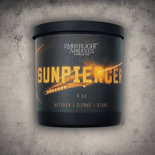 Emberlight Archives Sunpiercer candle in a 9oz black glass jar with illustrated spaceship label against a gray stone background, Citrus scent.