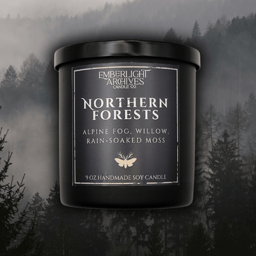 9oz Northern Forests candle by Emberlight Archives in a black glass jar with dark label against a forest background, Rain & Moss scent.