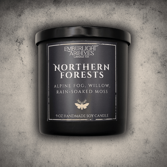 Emberlight Archives Northern Forests candle in a 9oz black glass jar with dark label against a gray stone background, Rain & Moss scent.