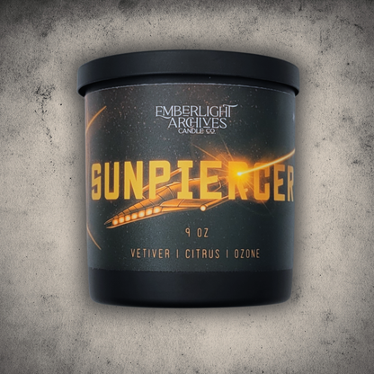 Emberlight Archives Sunpiercer candle in a 9oz black glass jar with illustrated spaceship label against a gray stone background, Citrus scent.