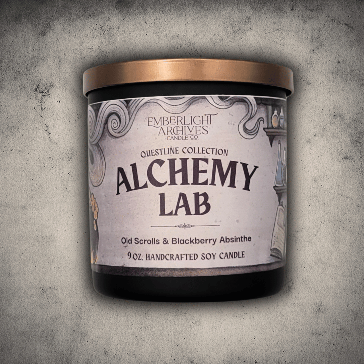 Emberlight Archives Alchemy Lab candle in a 9oz black glass jar with illustrated scrolls and potions label against a gray stone background, Old Scrolls and Blackberry Absinthe scent.