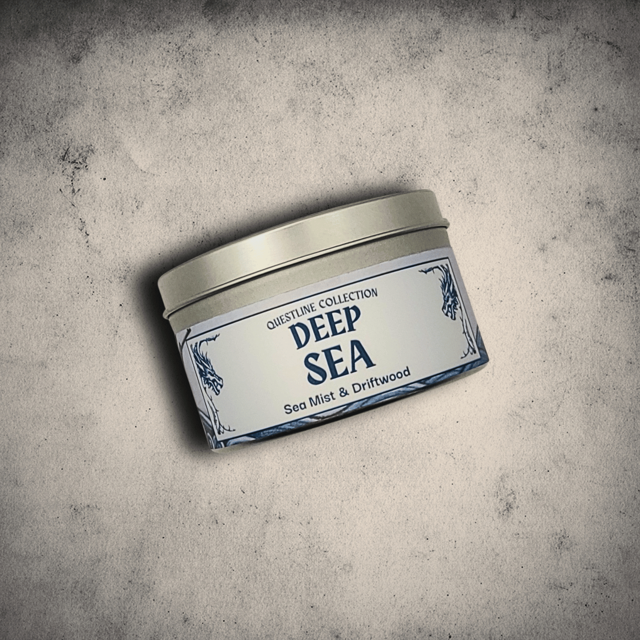 Emberlight Archives Deep Sea candle in an 8oz tin against a gray stone background, Sea Mist and driftwood scent.