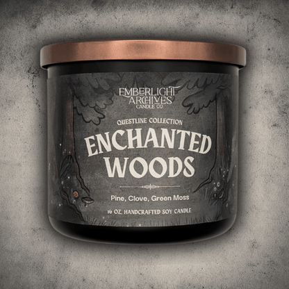 Emberlight Archives Enchanted Woods candle in a 16oz black glass jar with illustrated forest label against a gray stone background, Pine and Clove scent.