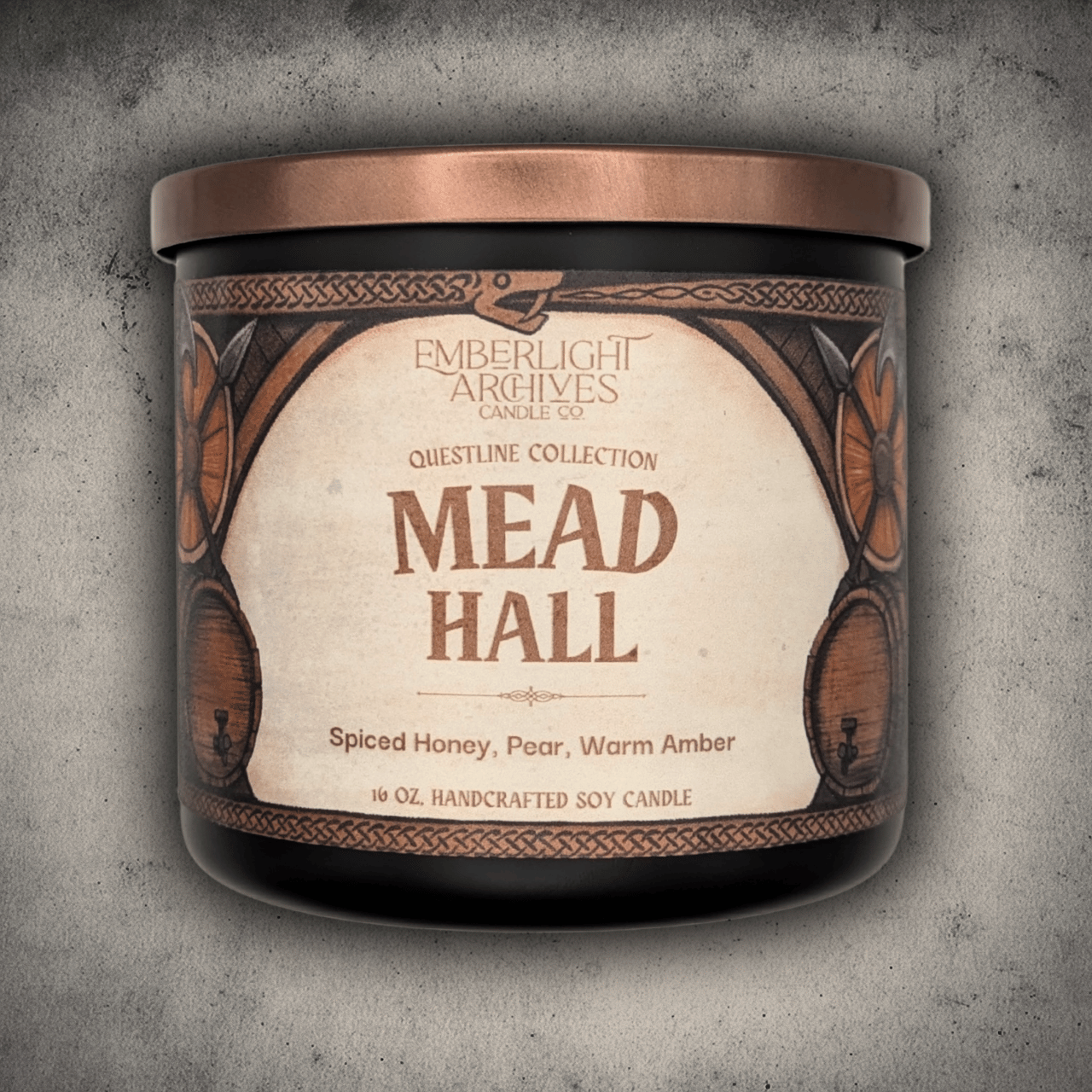 16oz Mead Hall candle in a 16oz black glass jar with illustrated label against a gray stone background, Pear and Spiced Honey scent.