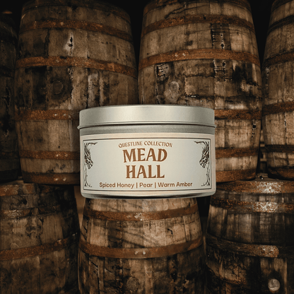 Mead Hall candle by Emberlight Archives in a silver tin against a mead barrels background, Pear and Spiced Honey scent.