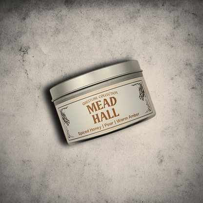 8oz Mead Hall candle in an 8oz tin with illustrated label against a gray stone background, Pear and Spiced Honey scent.
