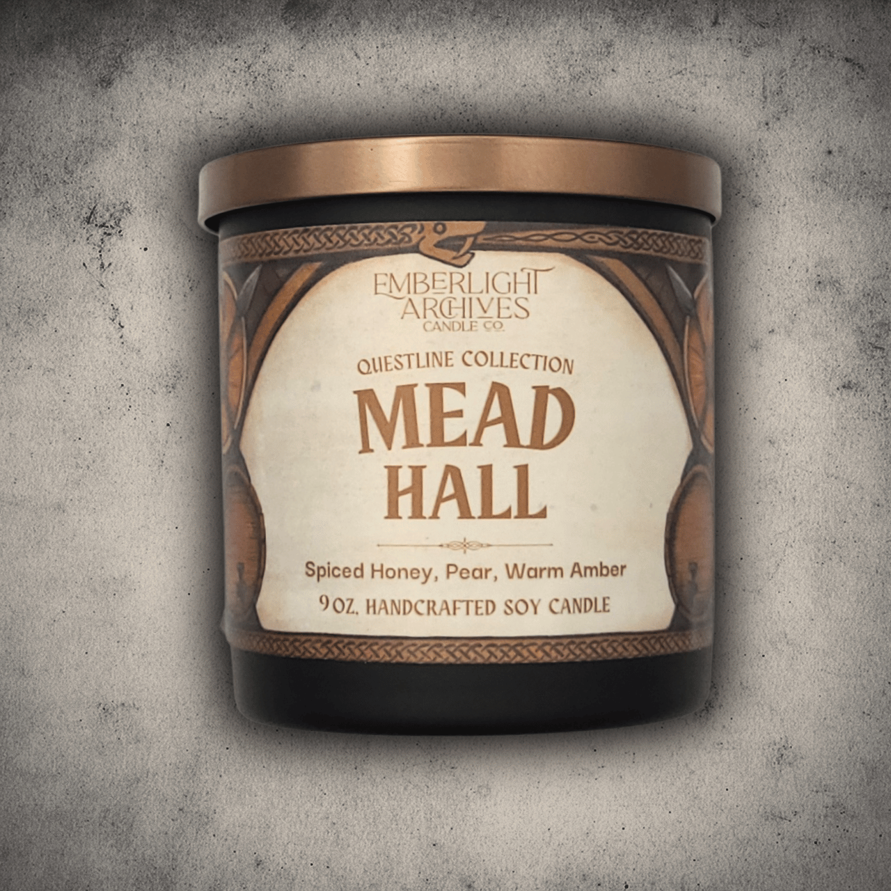 9oz Mead Hall candle in a 9oz black glass jar with illustrated label against a gray stone background, Pear and Spiced Honey scent.