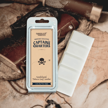 Captain's Quarters wax melt bar by Emberlight Archives with a tan label against a vintage table background with maps, Tobacco and Sandalwood scent.