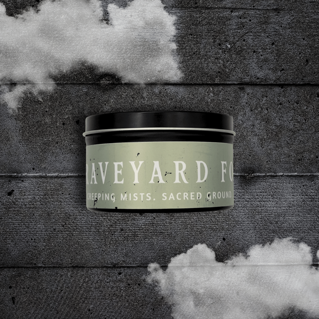 8oz Graveyard Fog candle by Emberlight Archives in a black tin with pale green label against a dark wood background.