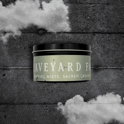 8oz Graveyard Fog candle by Emberlight Archives in a black tin with pale green label against a dark wood background.