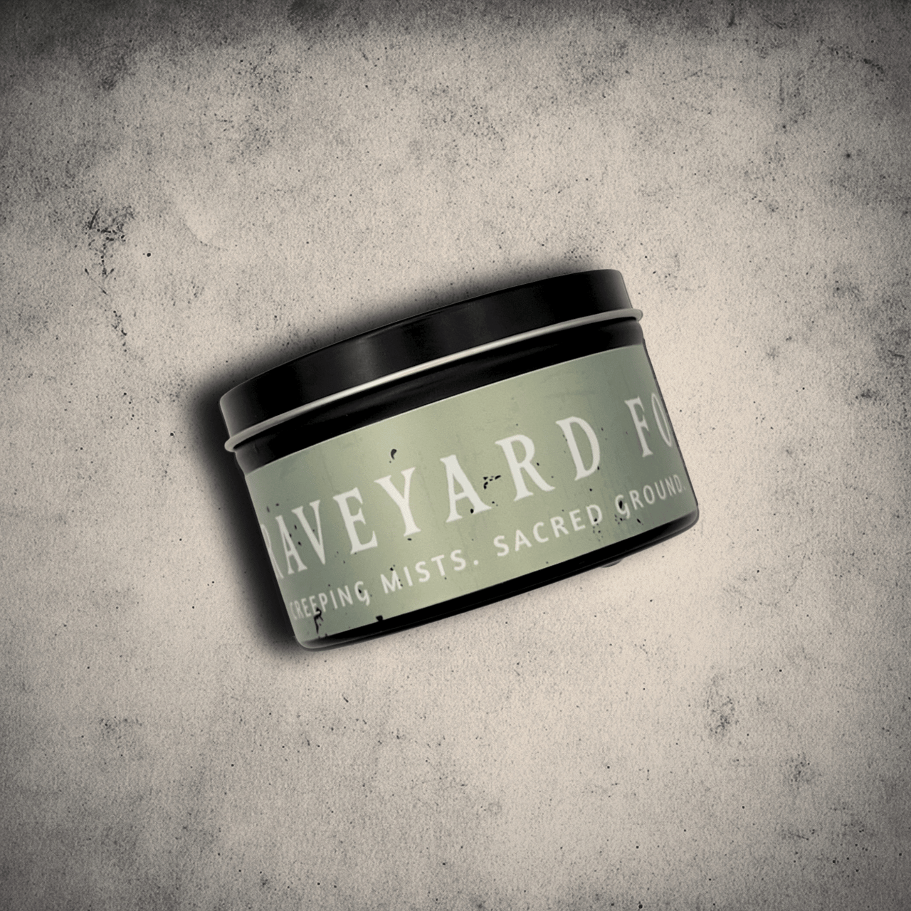 Graveyard Fog candle in an 8oz tin by Emberlight Archives on a textured gray background.