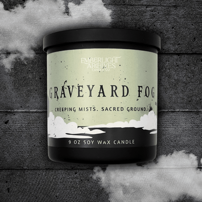 9oz candle in a black jar labeled 'Graveyard Fog' by Emberlight Archives on a textured dark background with smoke effect.