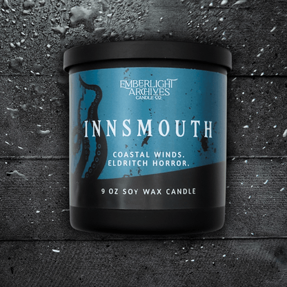 9oz Innsmouth candle by Emberlight Archives in a black glass jar with blue tentacles label against a dark wood background, Coastal Winds and Black Coral scent.