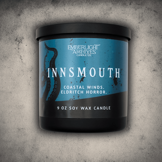 Emberlight Archives Innsmouth candle in a 9oz black glass jar with blue tentacles label against a gray stone background, Coastal Winds and Black Coral scent.
