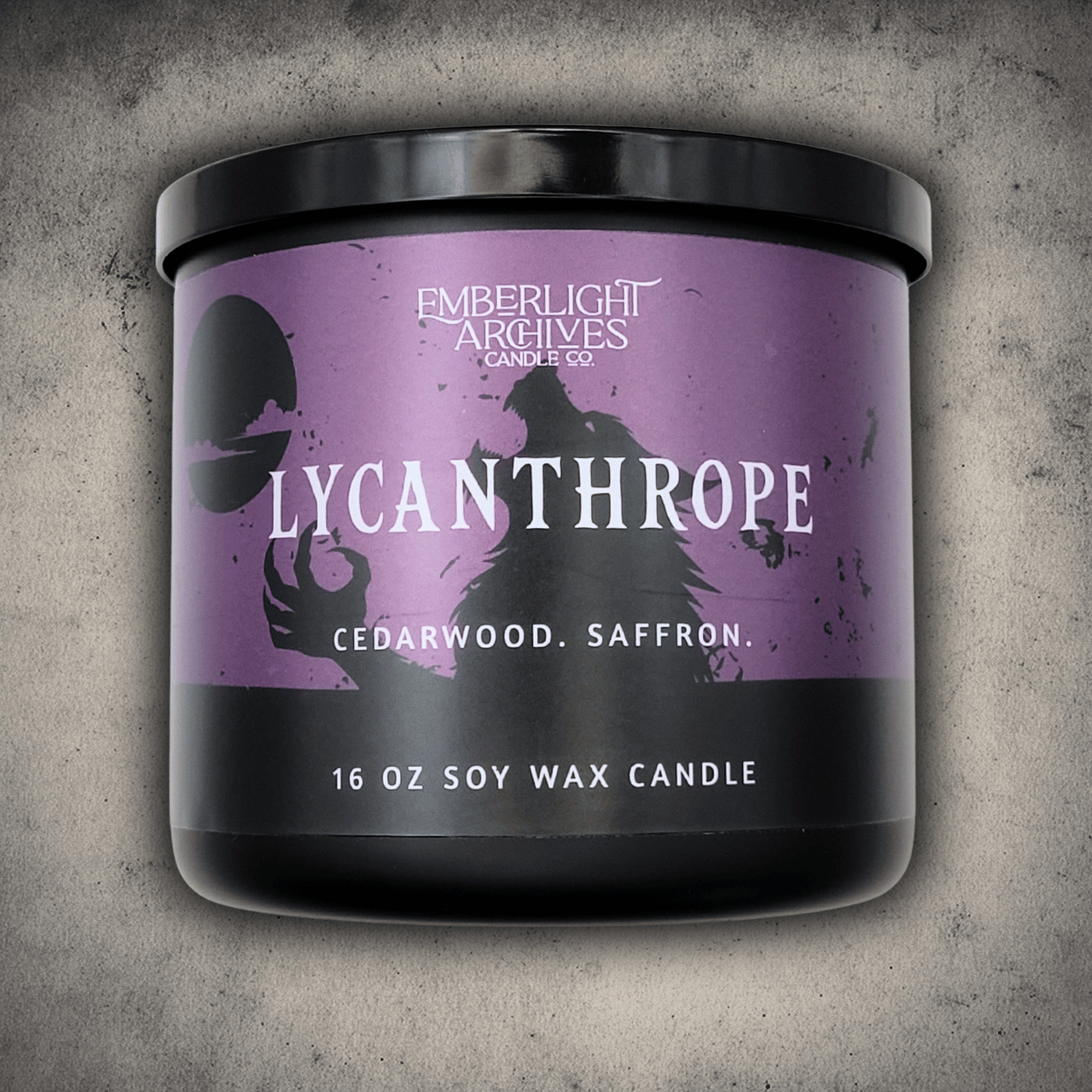 Emberlight Archives Lycanthrope horror candle – 16oz black glass jar with purple werewolf label against a gray stone background, Cedarwood & Saffron scent.