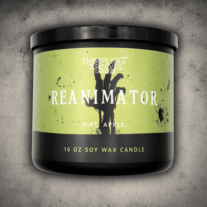 Emberlight Archives Reanimator candle in a 16oz black glass jar with bright green skeleton label against a gray stone background, Dirt and Apple scent.