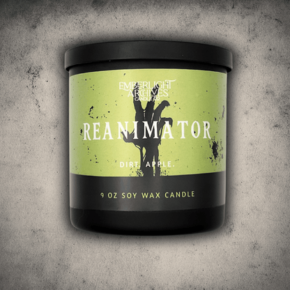 Emberlight Archives Reanimator candle in a 9oz black glass jar with bright green skeleton label against a gray stone background, Dirt and Apple scent.