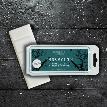 Innsmouth wax melt bar by Emberlight Archives with a blue label against a dark wood background, Coastal Winds and Black Coral scent.