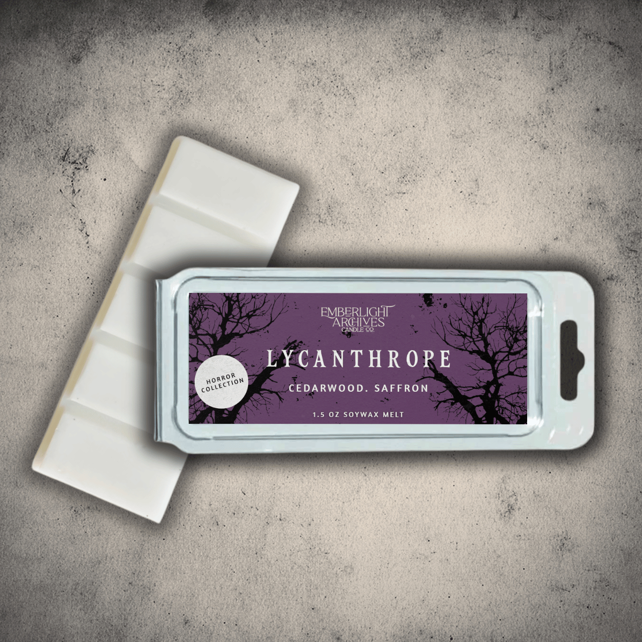 Emberlight Archives Lycanthrope wax melt bar with a purple label against a gray stone background, Cedarwood and Saffron scent.