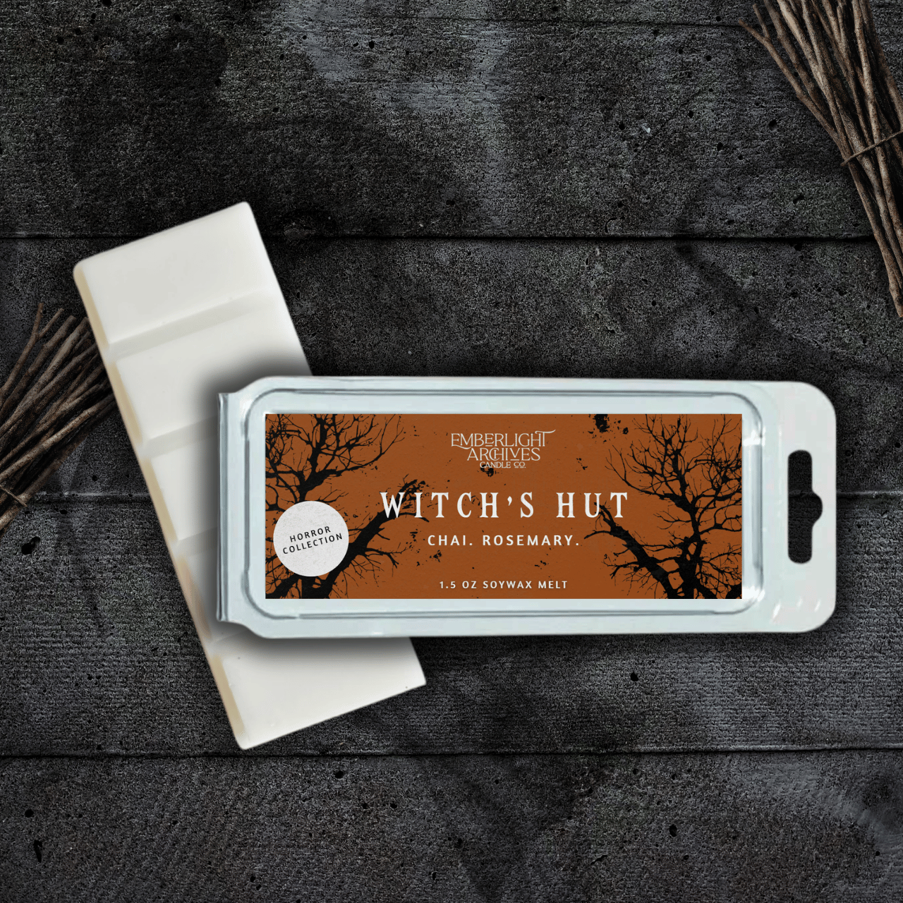 Witch's Hut wax melt bar by Emberlight Archives with an orange label against a dark wood background, Chai and Rosemary scent.