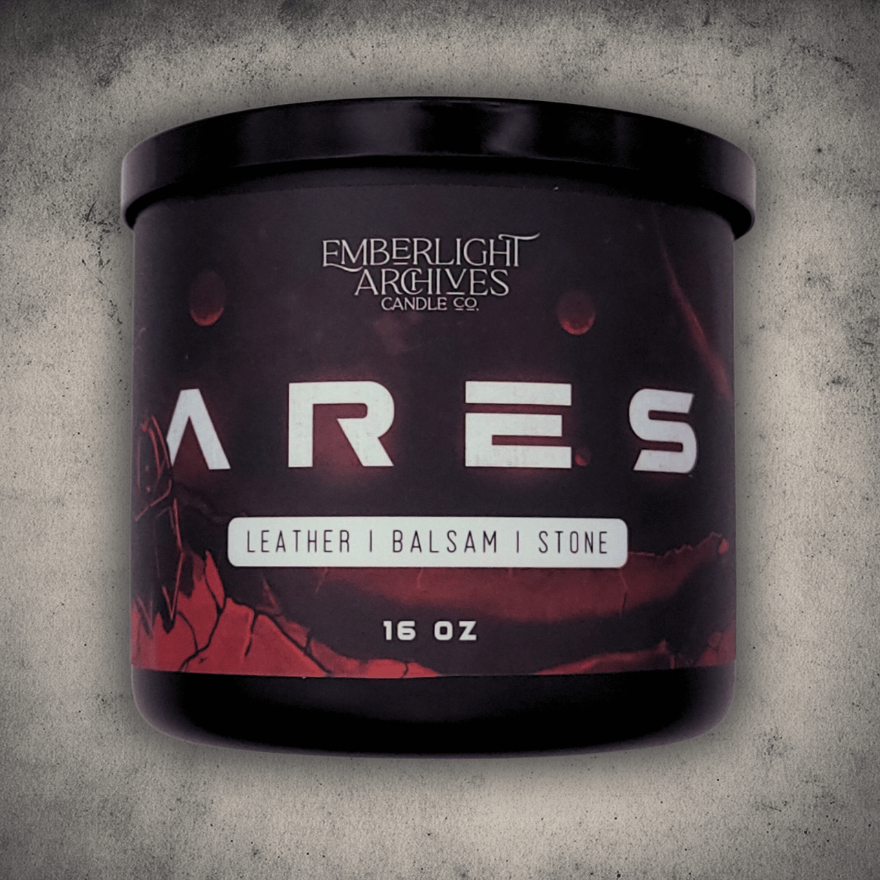 16oz Ares candle by Emberlight Archives in a black glass jar with illustrated red planet label against a stone background, Leather and Balsam scent.