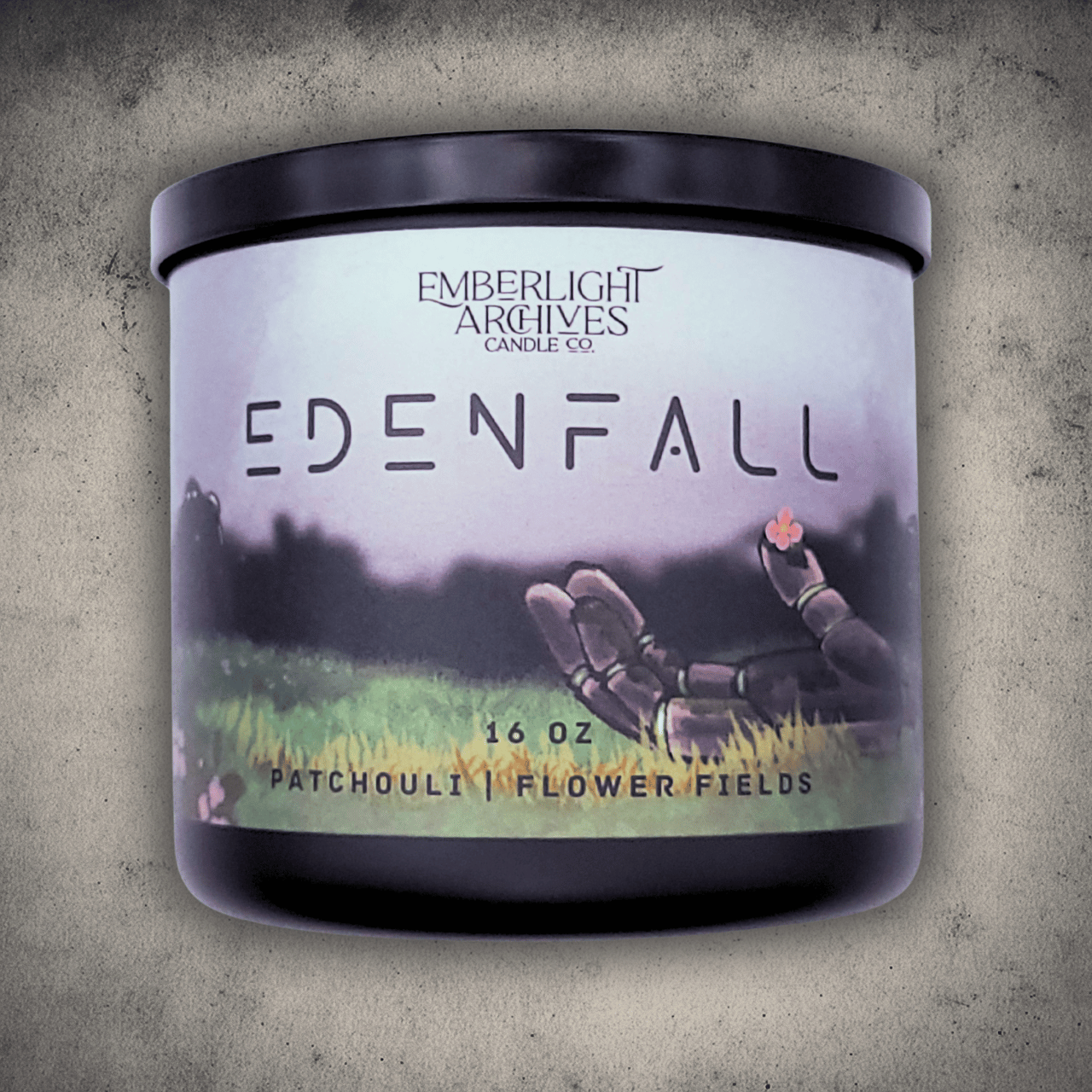 Emberlight Archives Edenfall candle in a 16oz black glass jar with illustrated sci-fi label against a gray stone background, Patchouli and Flower Fields scent.