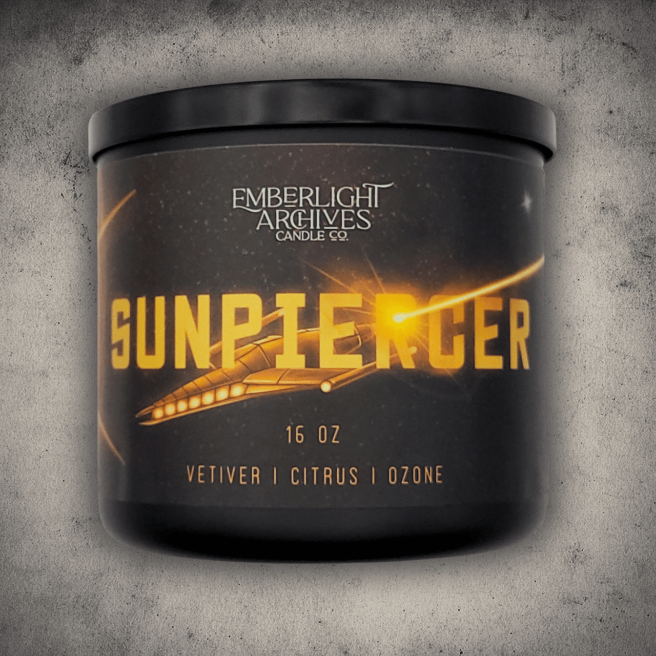 Emberlight Archives Sunpiercer candle in a 16oz black glass jar with illustrated spaceship label against a gray stone background, Citrus scent.