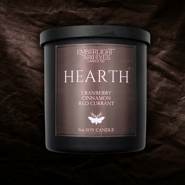 9oz Hearth candle by Emberlight Archives in a black glass jar with red label against a dark red background, Cranberry Cinnamon scent.