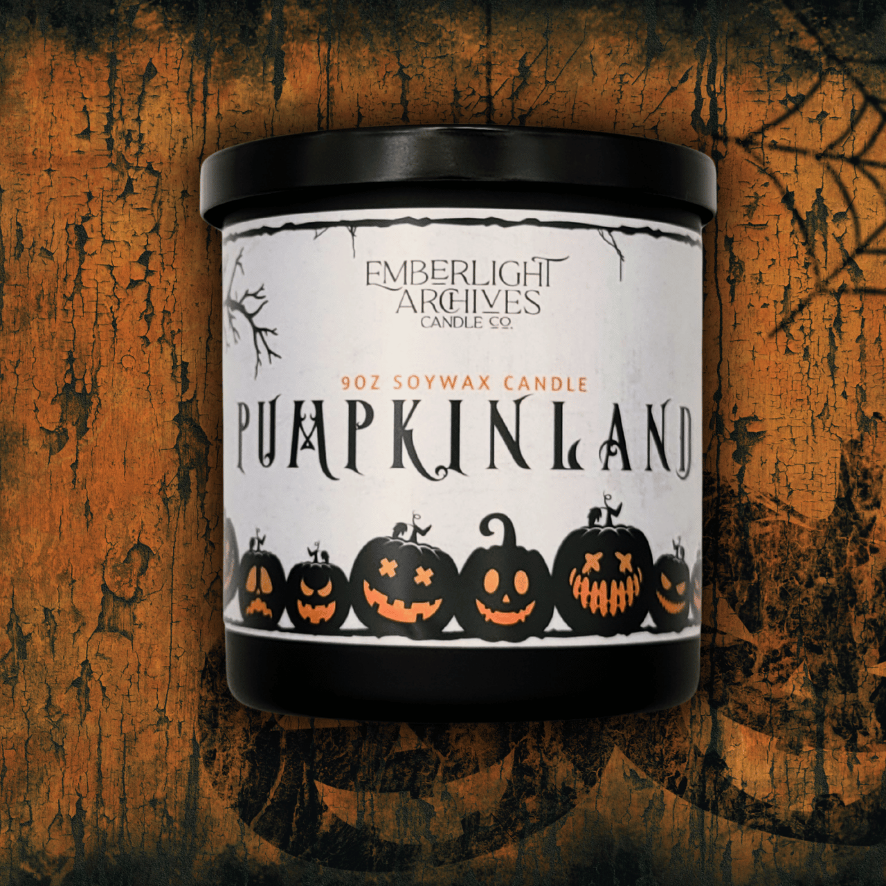 9oz Pumpkinland candle by Emberlight Archives in a black glass jar with white in label against a orange background, Pumpkin Pie scent.