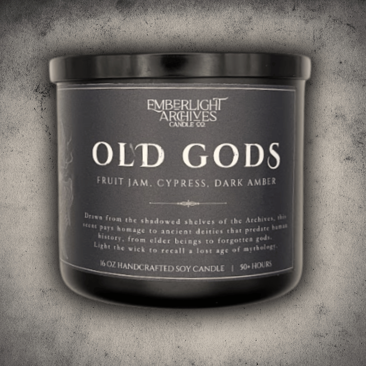 Emberlight Archives Old Gods candle in a 16oz black glass jar with dark label against a gray stone background, Fruit Jam & Musk scent.