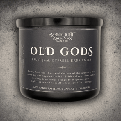 Emberlight Archives Old Gods candle in a 16oz black glass jar with dark label against a gray stone background, Fruit Jam & Musk scent.